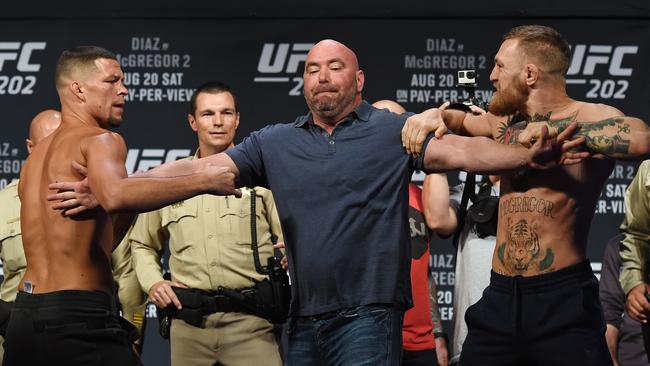 UFC President Dana White (C) separates Nate Diaz (L) and Conor McGregor.