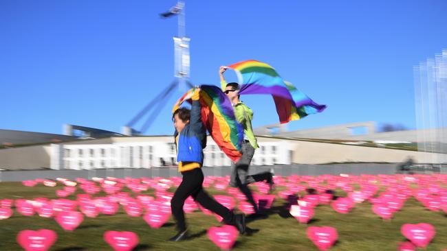 Marriage equality advocate Russell Nankervis (right) and a child run through the 'Sea of Hearts' event supporting Marriage Equality outside Parliament House in Canberra this week. (Pic: Lukas Coch/AAP)                        <a capiid="f23aab0927bc92696e3ecfff179359fb" class="capi-video">Opposition leader encourages 'yes' vote</a>