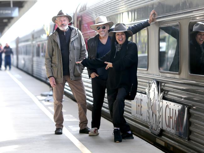 Shane Howard, Joe Camilleri and Christina Anu pose for a photograph on the platform before departing for Darwin in Adelaide, Sunday, August 4, 2019. They will be performing a concert as part of the 90th anniversary of the Ghan. The Ghan train service will mark 90 years of operations on Sunday with a special service leaving Adelaide for Darwin. (AAP Image/Kelly Barnes) NO ARCHIVING