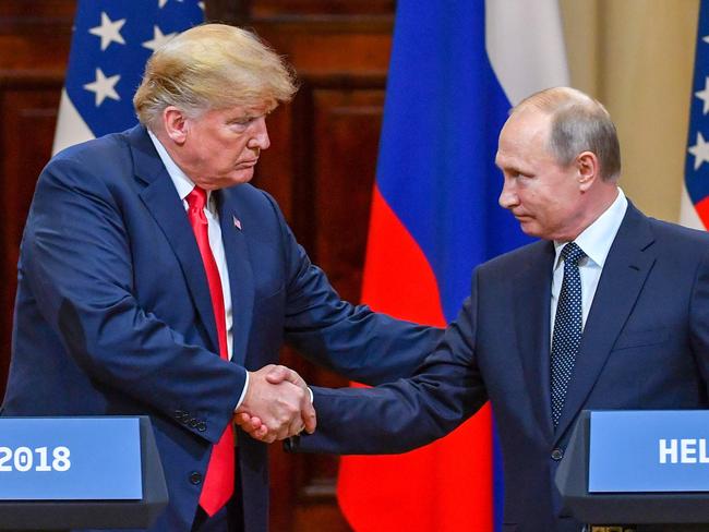 Donald Trump and Vladimir Putin shake hands. Pic: AFP