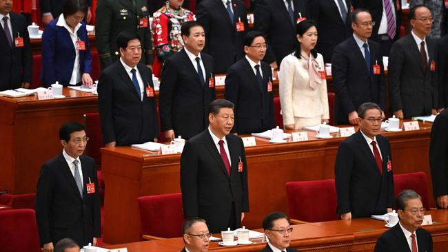 China's President Xi Jinping (C), Premier Li Qiang (R) and Politburo Standing Committee member Wang Huning (L) sing the national anthem during the opening session of the National People's Congress at the Great Hall of the People.