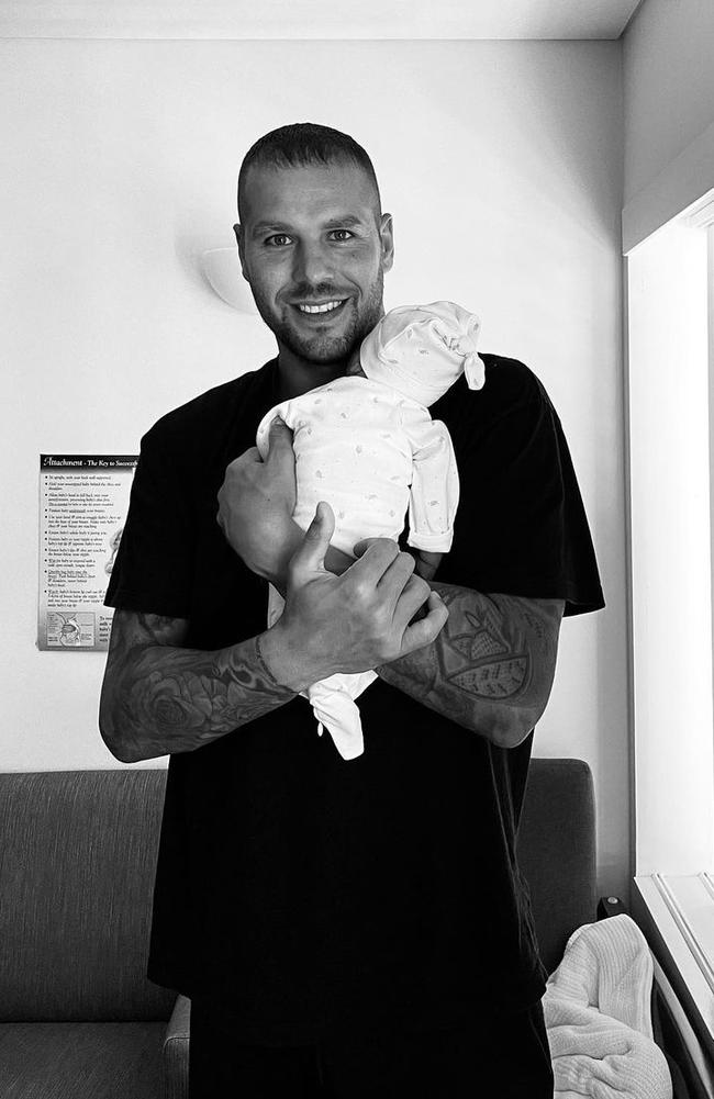 Buddy Franklin holds his newborn baby boy.