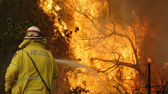 A Tuncurry fire crew member fights part of the Hillville bushfire south of Taree. Picture: AAP