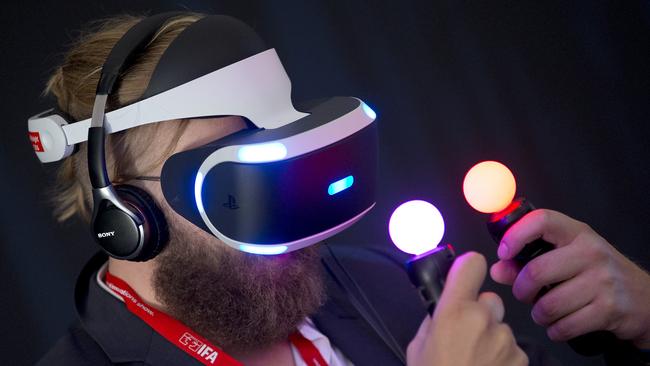 A man tests a Sony’s PlayStation VR headset and its move controllers.