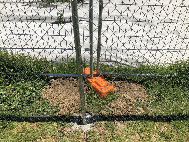 The temporary and permanent fencing guarding against a tarp covering asbestos. Picture: Tony Ibrahim