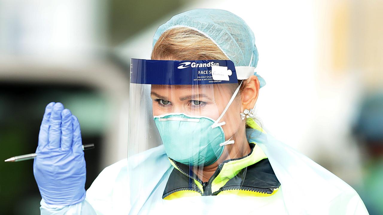 A healthcare worker gestures at a car to come forward at a testing centre in Bondi, NSW. Testing, tracking and tracing is vital to stopping the spread of the disease. Picture: Mark Metcalfe/Getty Images.