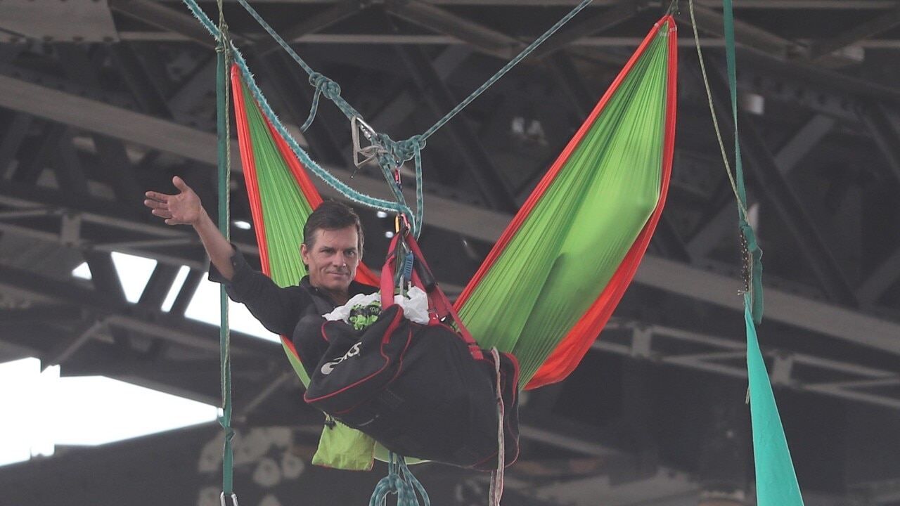 Story Bridge protestor climbs back to safety