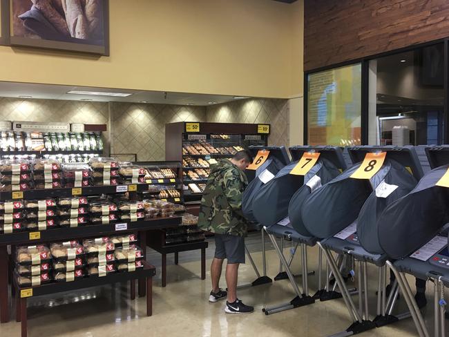 Only in America.... A man votes in the bakery department at a Randalls grocery store in Austin, Texas, on Tuesday, Nov. 8, 2016. Picture: Jay Janner/Austin American-Statesman via AP