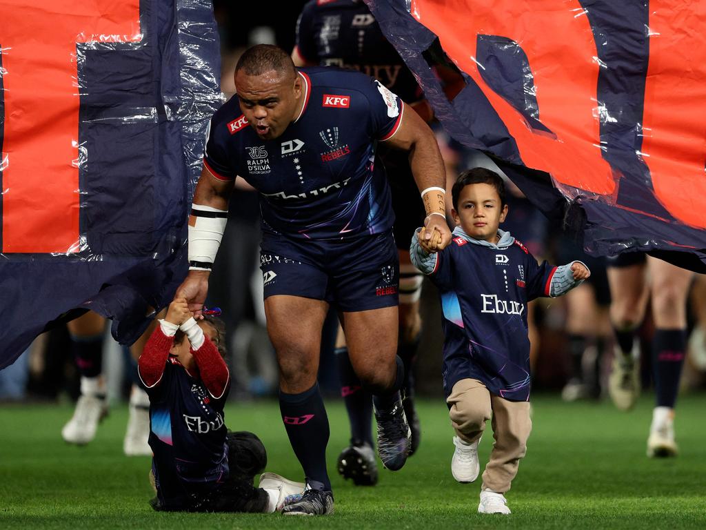 Rebels Sam Talakai runs through the banner with his children before the Super Rugby match between the Melbourne Rebels and Waikato Chiefs. Picture: AFP