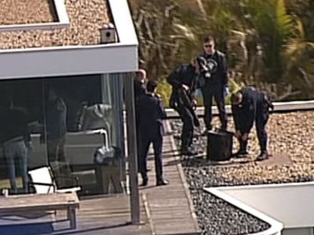 Police use a battering ram to crack open a safe during a raid of John Ibrahim’s house this week. Picture: Channel 7