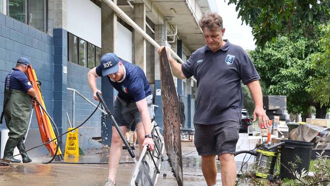 Members of the Brisbane City soccer club clean up flood damage. Picture: NewsWire/Tertius Pickard