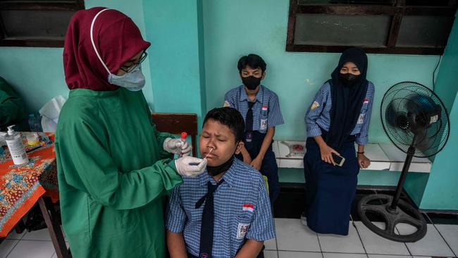 A health worker conducts a Covid tests for students at a junior high school in Surabaya, Indonesia. Picture: AFP