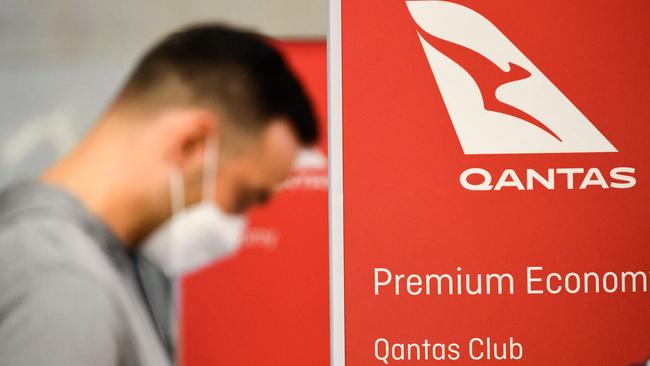 Travellers wait in line after verifying their Covid-19 vaccination status as they check-in for a flight to Sydney, Australia on Qantas Airways Ltd. inside the Tom Bradley International Terminal at Los Angeles International Airport (LAX).