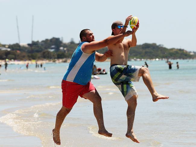 Jake Robertson (left) and Aaron O'Mara of East Bentleigh make their mark on Rye beach on December 31, 2012. Picture: Hamish Blair