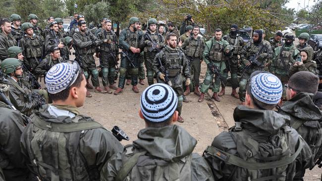 Israeli soldiers are briefed as they prepare to return to the Gaza Strip, near the border area in southern Israel. Picture: AFP