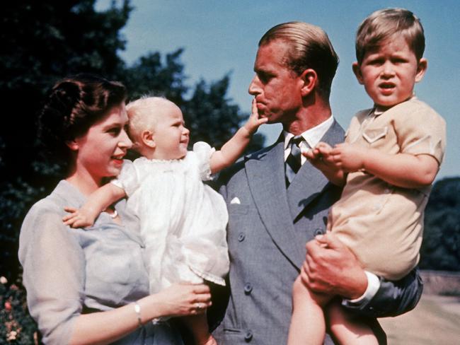 The first colour photograph of Princess Anne, taken in 1951, in the arms of her mother Queen Elizabeth II while her father, Philip, holds her brother Prince Charles. Picture: Getty