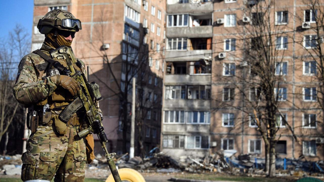 A Russian soldier stands in front of an apartment building in Donetsk, which the Russian authorities say was damaged by Ukrainian shelling. Picture: Alexander NEMENOV / AFP