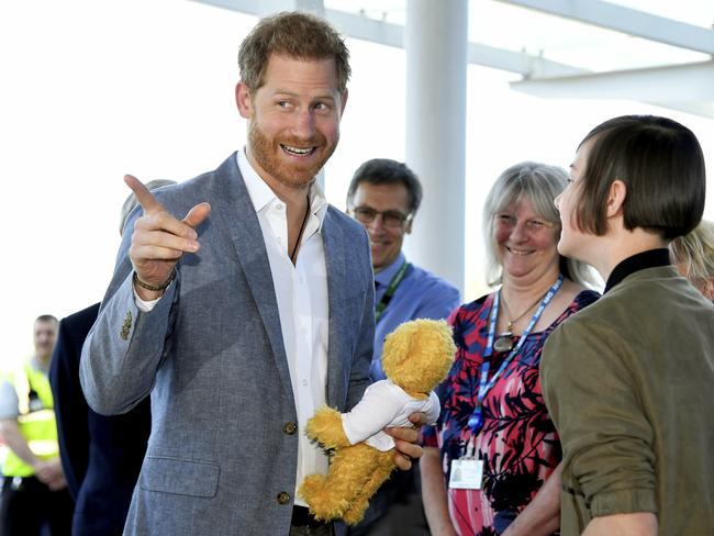 The new father laughs as he receives the teddy bear. Picture:  AP