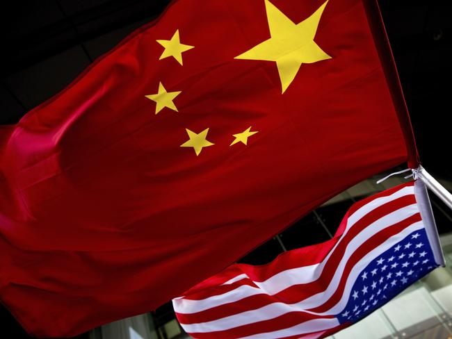 FILE - In this Nov. 7, 2012, filephoto, U.S. and Chinese national flags are hung outside a hotel during the U.S. Presidential election event, organized by the U.S. embassy in Beijing. A government report is outlining how spy services from China, Russia and Iran are hard at work trying to steal trade secrets and proprietary information from U.S. companies, government labs and universities.(AP Photo/Andy Wong, File)