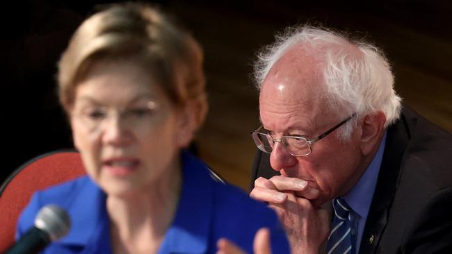 Democratic presidential candidate Bernie Sanders listens as Elizabeth Warren speaks.