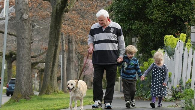 Grant takes his dog Millie and children William and Beatrice for a walk outside his home in Glen Iris. 