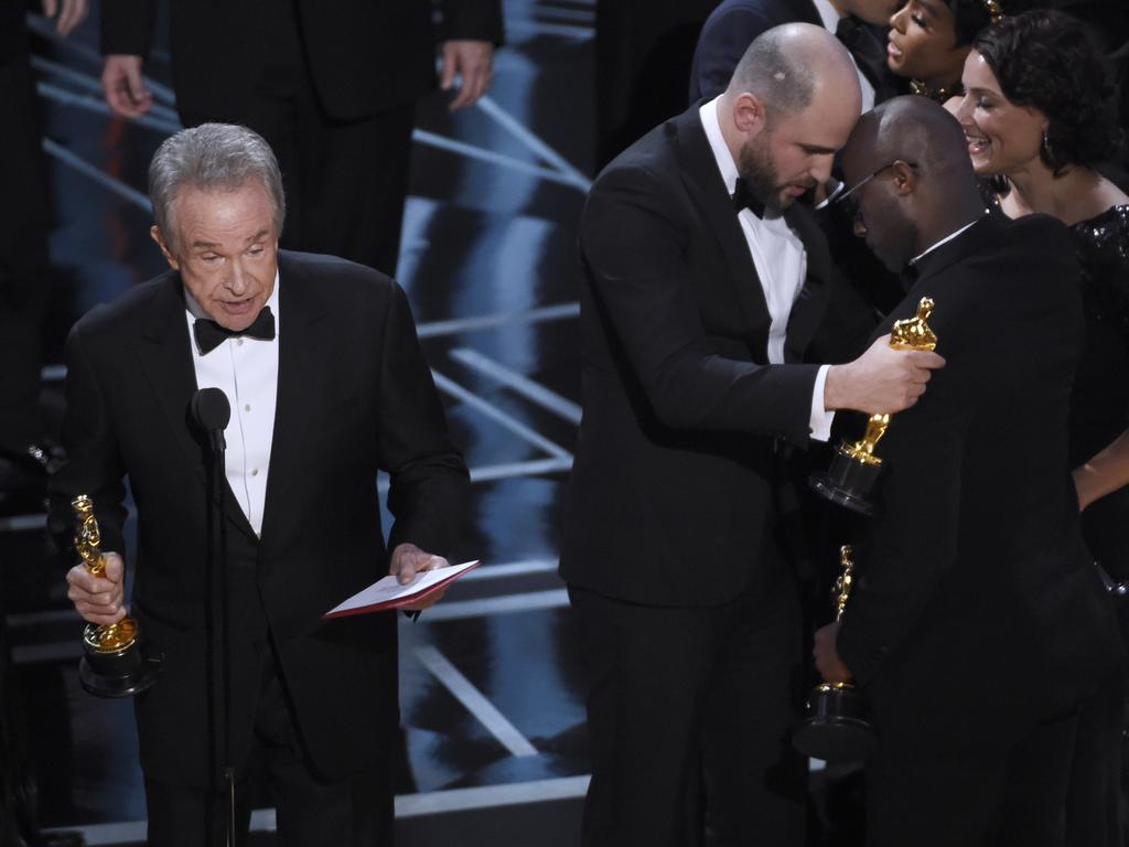 Warren Beatty addresses the audience as Jordan Horowitz embraces Barry Jenkins during the 89th Annual Academy Awards. Picture: AP