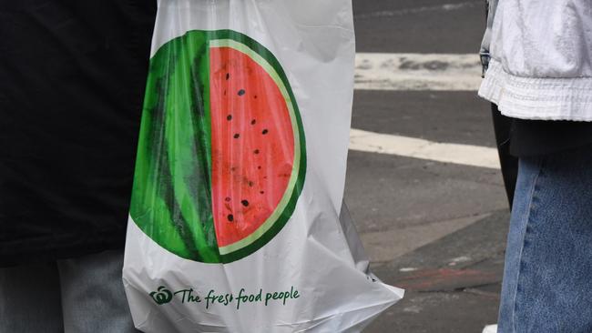 A shopper carries a reusable plastic bag out of a Woolworths’ CBD store. Picture: AAP