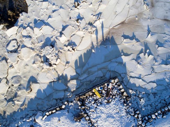 Surfers look at the water from ice plates, on March 5, 2018 in Henningsvaer, northern Norway, Lofoten islands, within the Arctic Circle. Picture: AFP