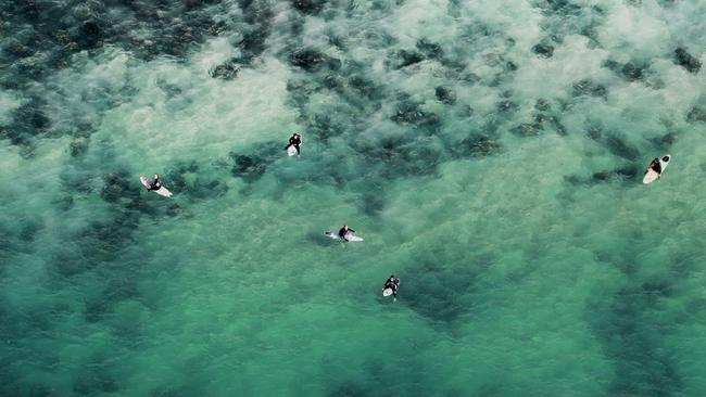 Surfers wait for waves at Burleigh Point. Picture: Luke Marsden.