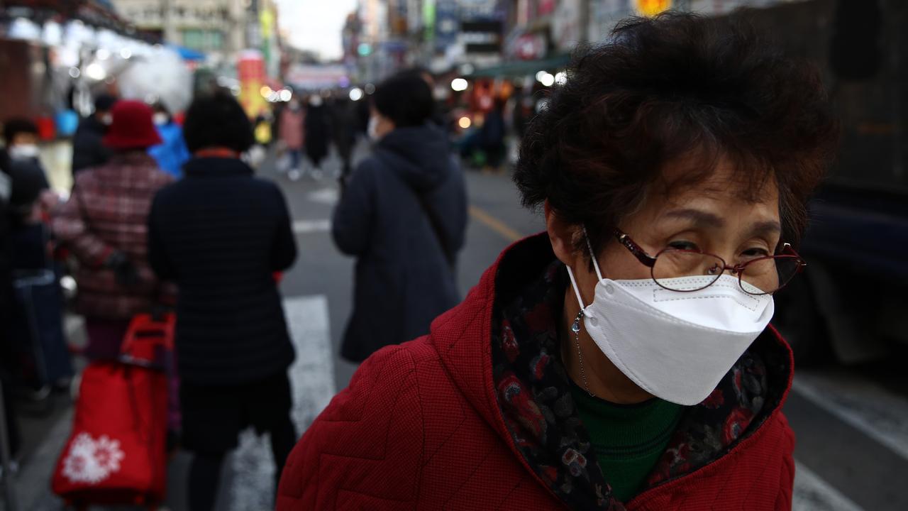 People walk along a street in a traditional market in Seoul, South Korea. Picture: Chung Sung-Jun/Getty Images