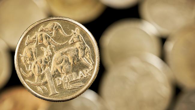 Australian one dollar coin over blurred golden background.