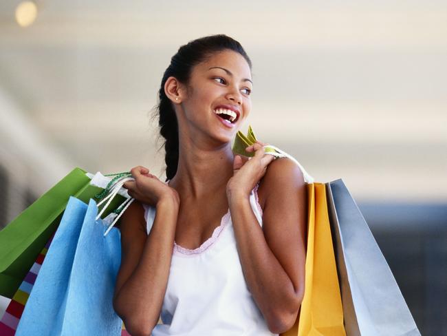 Generic image of young woman carrying shopping bags, laughing, close-up.