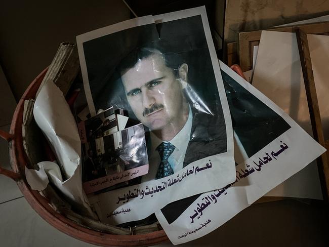 Posters and framed portraits of Bashar al-Assad are seen in the bin in Damascus. Picture: McGrath/Getty Images