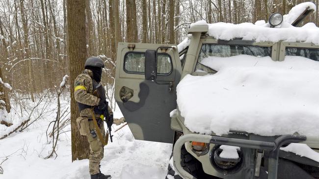 A member of the Ukrainian Territorial Defence Forces looks at a Russian military vehicle in a forest outside Ukraine's second-biggest city of Kharkiv on March 7. Picture: AFP