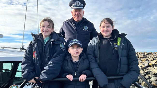 Commissioner of Police Grant Stevens with Sergeant Sammy and sisters and Abigail and Erin Scully at Port River with the South Australia Police’s Water Operations Unit on Tuesday. Picture: SAPOL