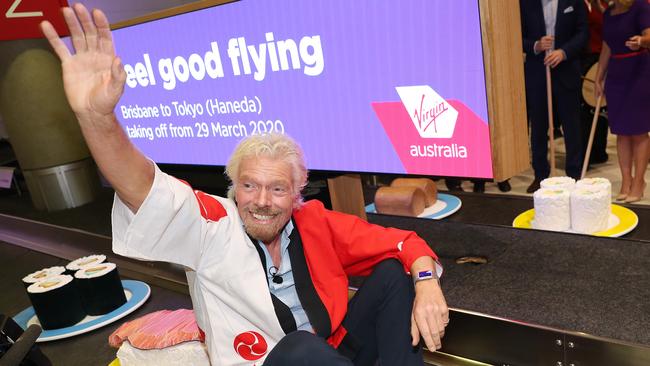 Never afraid of a promotional stunt, Richard Branson rides a makeshift sushi train to promote the launch of a new Virgin Australia to Japan. Picture: Liam Kidston.