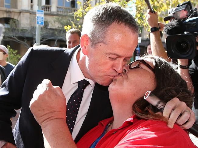 ... aaaand gives into the kiss of Margo Carey, 49, in Adelaide. Picture: Kym Smith