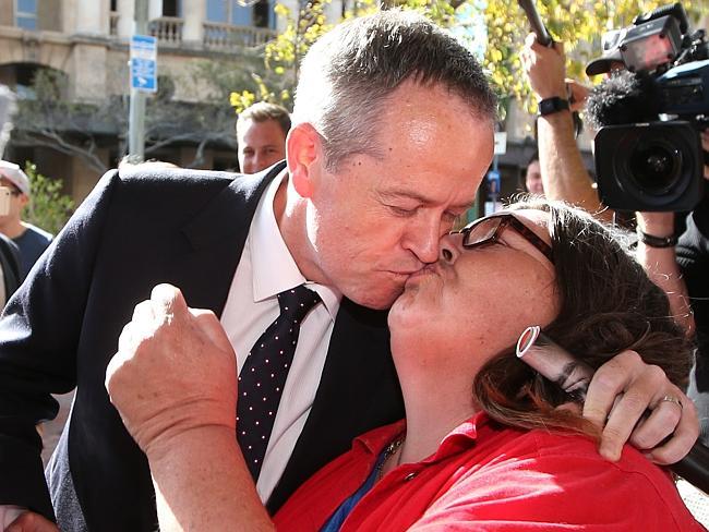 ... aaaand gives into the kiss of Margo Carey, 49, in Adelaide. Picture: Kym Smith