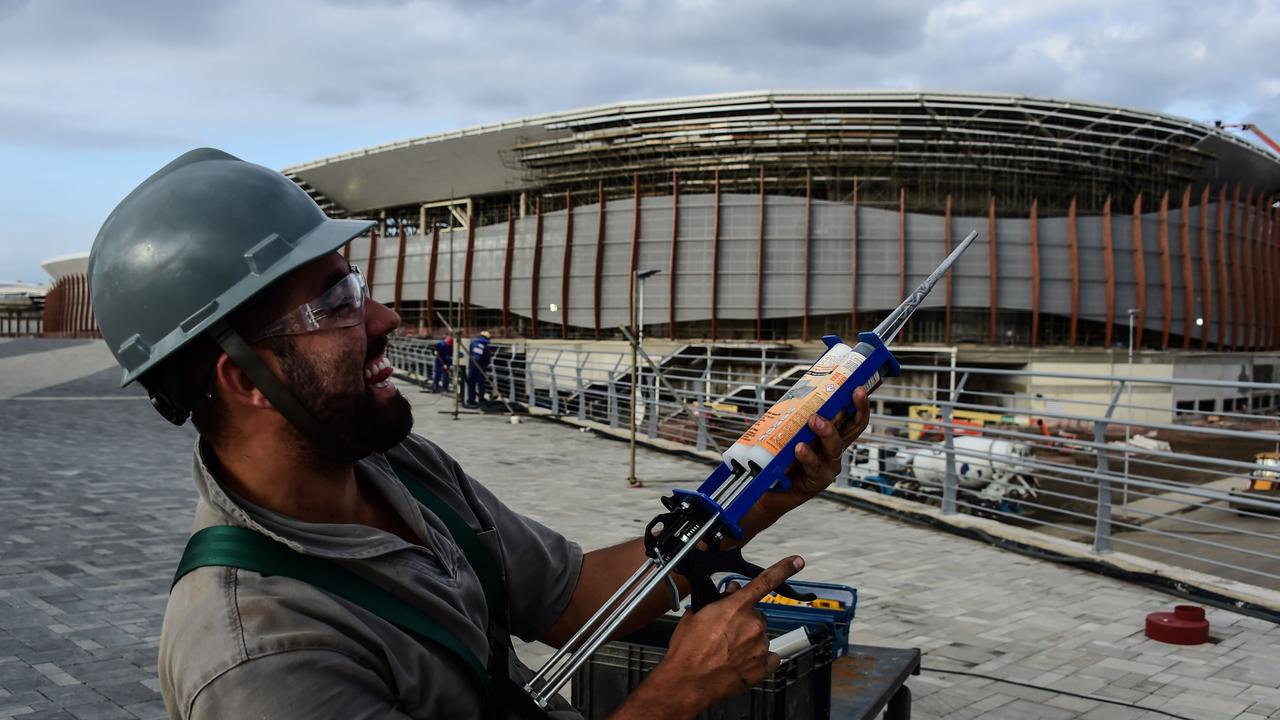 A worker poses for a photo at the construction site of the Olympic Park for the Rio 2016 Olympic games in Rio de Janeiro, Brazil, on October 6, 2015. AFP PHOTO / CHRISTOPHE SIMON