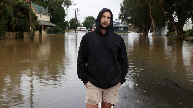 Josh Wade outside his flooded plumbing business in Camden. Over 150mm of rain has fallen in the last 24 hours. Picture: Jonathan Ng