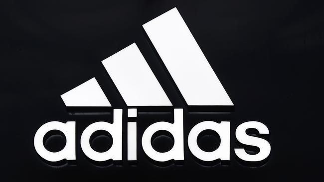 The logo of German sport brand Adidas is pictured on a store in Berlin on January 25, 2016. / AFP / TOBIAS SCHWARZ