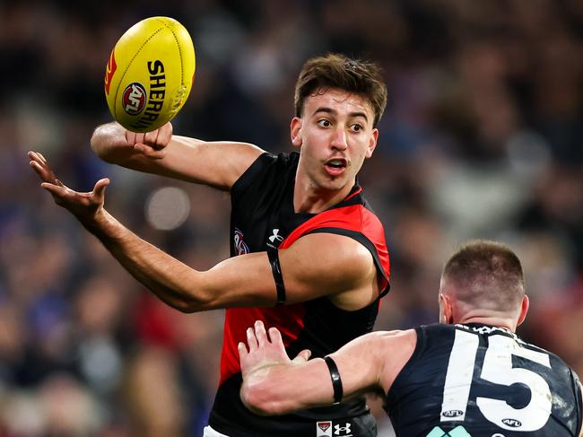 MELBOURNE, AUSTRALIA - JUNE 11: Nic Martin of the Bombers handpasses the ball during the 2023 AFL Round 13 match between the Carlton Blues and the Essendon Bombers at the Melbourne Cricket Ground on June 11, 2023 in Melbourne, Australia. (Photo by Dylan Burns/AFL Photos via Getty Images)