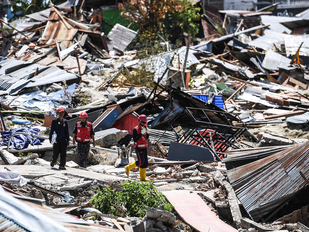 Rescuers walk past debris at Perumnas Balaroa village in Palu, Indonesia's Central Sulawesi on October 5, 2018, following the September 28 earthquake and tsunami. Picture: Mohd Rasfan