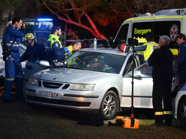 Ambulance paramedics, a CareFlight crew and police treat John Dunne in a car in Coonanga Rd, Avalon, with a speargun spear in his chest. Picture: Sebastien Dekker