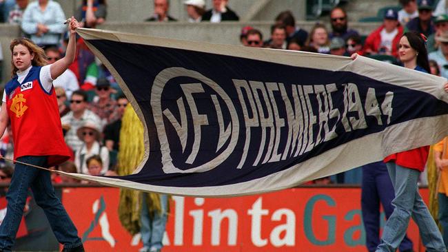 Supporters unfurl Fitzroy’s 1944 premiership flag at Subiaco before the team’s last AFL match. Picture: HWT