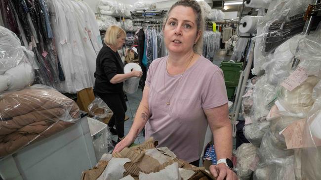 Staff at Smoothline Dry Cleaners tackle the flood damage. Picture: Tony Gough