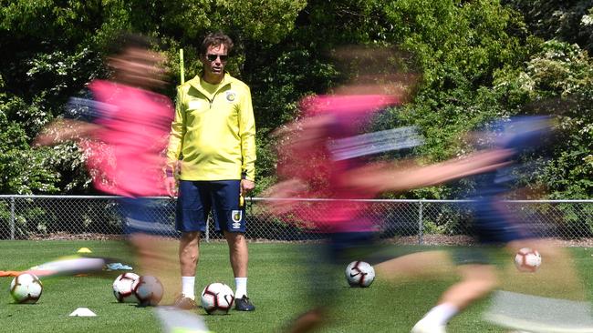 Central Coast Mariners coach Mike Mulvey watches his squad in Gosford yesterday. Picture: AAP.
