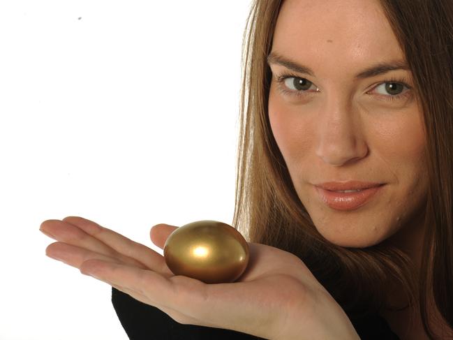 Your Money superannuation generic images. Woman holding golden nest egg in her hand.