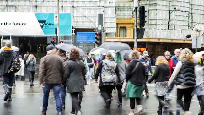 Melburnians cross Flinders St in the rain. Rainy days in Melbourne might be common this Summer. Picture: Sarah Matray