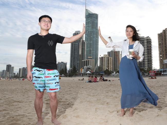 Chinese tourists are flocking to the Gold Coast in large numbers. Weihua Chen (23) and Dongwan Wang (22) having fun on Surfers Paradise beach. Picture by Scott Fletcher